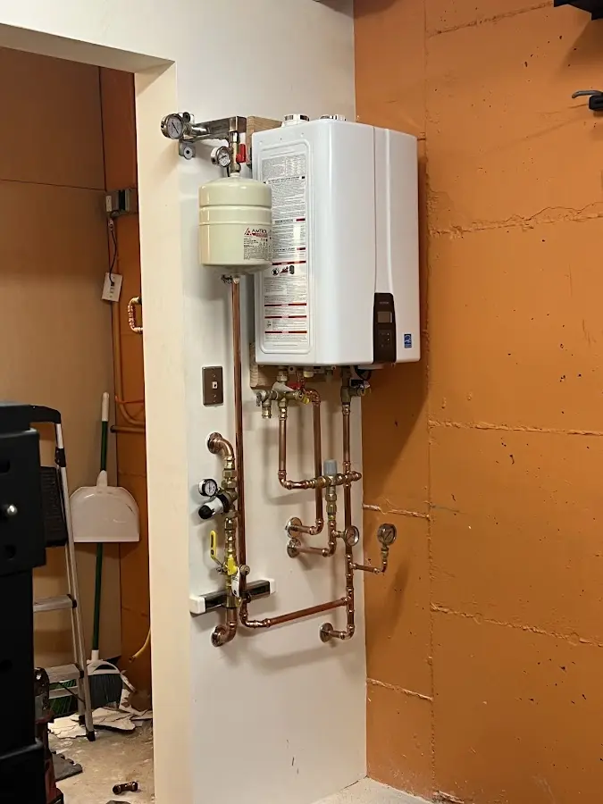 Plumbing technician inspecting water heater connections in Beardstown